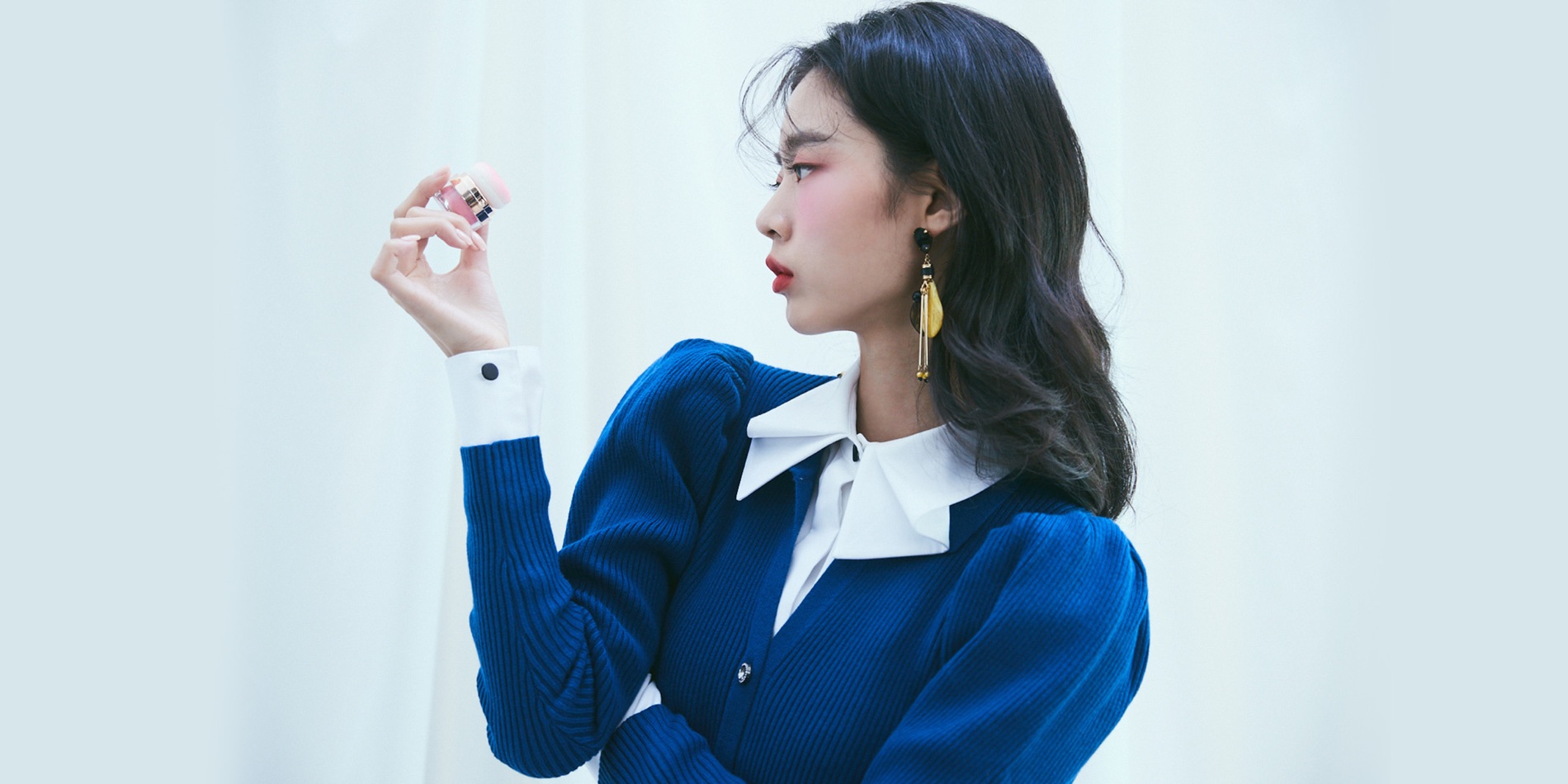 조이코스 캠페인 — 블루 니트를 입고 제품을 든 모델